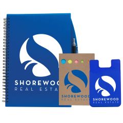 A blue journal with a white logo next to a natural coloured sticky note set with a blue logo and a blue silicone cellphone sleeve with a white logo next to that