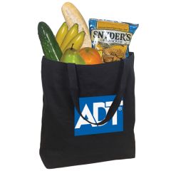 A large, black sturdy cotton canvas tote filled with food. The print on the front is white and blue.